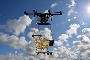 A Drone is flying in the sky with a shipping trolley underneath 