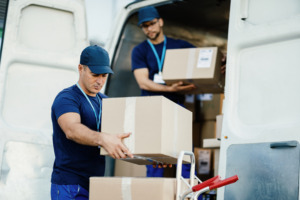 oung-courier-his-colleague-unloading-cardboard-boxes-from-delivery-van-scaled